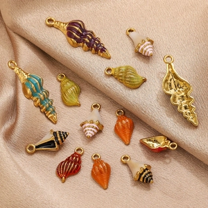 Détails macro de pendentifs coquillages et conques en émail coloré sur soie