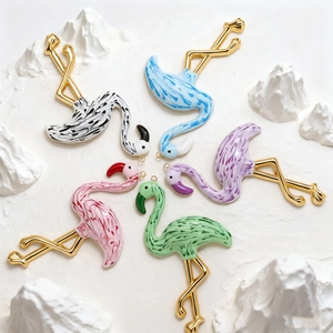 Detailed macro view of colorful flamingo charms with marble texture and gold plated finish