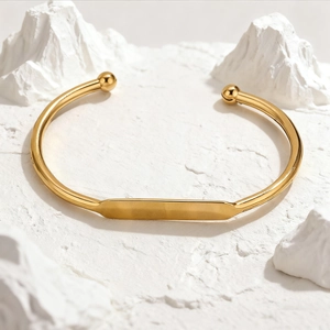 Polished 18K gold stainless steel open bangle with a blank engravable rectangular nameplate