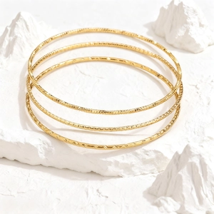 Brazaletes apilables de acero de titanio dorado martillado para mujer de estilo minimal