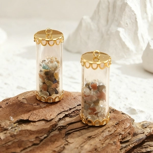 DIY glass tube pendants with natural stone chips and golden lace caps on wood