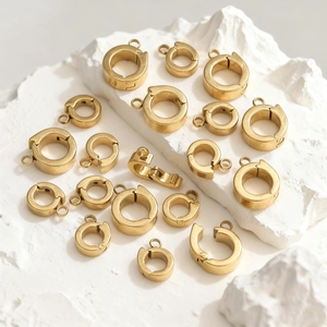 Goldene Edelstahl-Federringverschlüsse für DIY-Schmuck auf weißem Steinsockel