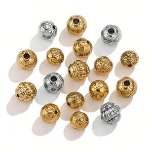 Gros plan de perles métalliques gaufrées vintage en or et argent pour bijoux DIY