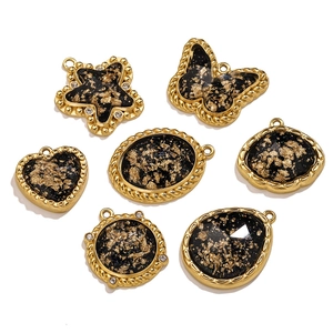 Detail of vintage black gold charms with gold foil inlay for DIY jewelry making