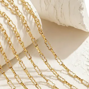 Macro shot of gold undulated stainless steel chains with irregular peanut links on white stone
