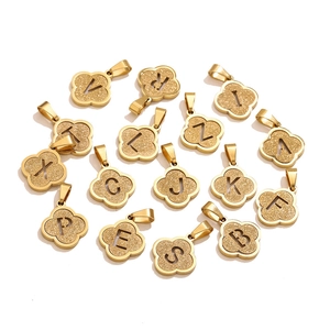 Detailed macro view of gold-plated clover charms with frosted texture and hollow letters
