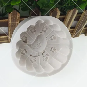 Macro detail of a white silicone mold featuring intricate bird and flower relief patterns