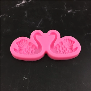 Pink swan silicone mold for fondant and DIY crafts on a black marble background