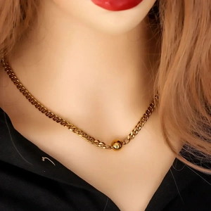 Polished gold cuban chain necklace featuring a smooth spherical ball pendant centerpiece