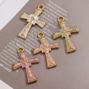 Detailed macro view of 18K gold plated cross pendants with colorful enamel and crystals