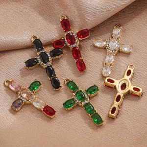 Macro shot of 18K gold plated stainless steel cross pendants with multi-color gemstones