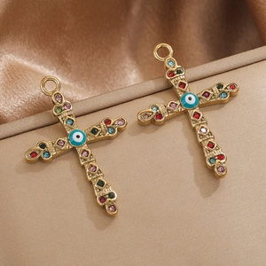 Detail of 18K gold plated cross pendants with colorful rhinestones and evil eye symbol