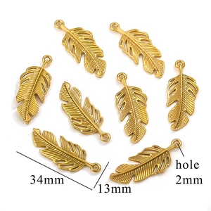 Détail de breloques plumes dorées de 34mm avec texture pour la création de bijoux