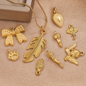 Ensemble de pendentifs en acier doré avec nœud et feuille sur fond en soie chic