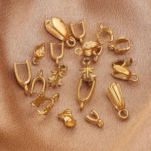 Golden stainless steel jewelry pinch bails in various leaf and star designs on satin