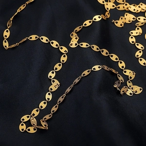 Flat gold stainless steel pig nose chain link bracelet on elegant blue silk fabric