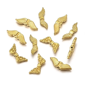 Macro detail of golden wing-shaped beads with feather texture for DIY jewelry making