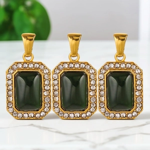 Tres elegantes colgantes rectangulares verde esmeralda bañados en oro sobre mármol