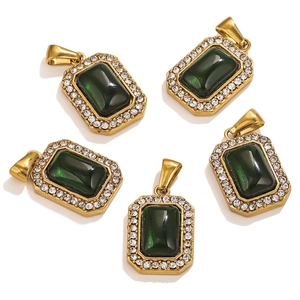 Detalle de cinco colgantes rectangulares dorados con gemas verdes y borde de cristal