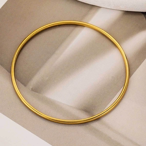Bracciale rigido minimalista in acciaio inossidabile placcato oro 18 carati su sfondo marrone