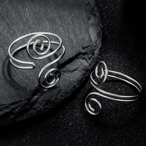 Minimalist silver steel double layer spiral ring on black stone background