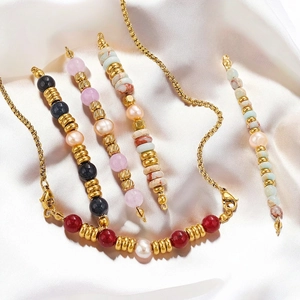 Detailed view of natural stone and pearl beaded necklace with gold stainless steel chain