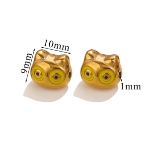 Macro view of gold-plated cat-shaped metal beads with enamel eyes for DIY jewelry