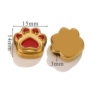 Macro detail of golden cat paw beads with red enamel for DIY jewelry making 15mm