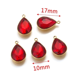 Macro detail of red teardrop crystal pendants with gold metal frames for DIY jewelry