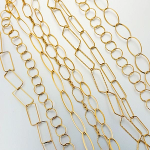 Close-up of various 18K gold plated DIY jewelry chain styles including textured oval links
