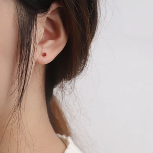 Minimalist red gemstone stud earring with gold base on model side view profile
