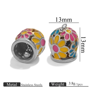 Detalle de colgantes de campana de acero de 13 mm con motivos florales de esmalte