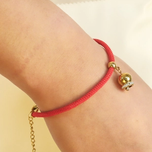 Red braided rope bracelet with gold bell charm and adjustable metal extender chain