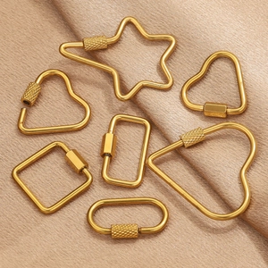 Golden stainless steel screw clasps in various geometric shapes on elegant satin fabric