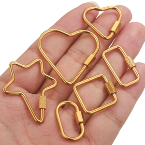 Gold stainless steel screw clasps in assorted geometric shapes held in palm