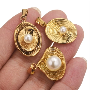 Close-up of golden irregular pearl pendants with sunburst and scallop patterns