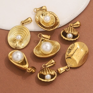Macro view of golden stainless steel shell and round pendants with faux pearl inlays