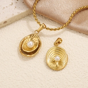 Macro detail of gold-plated twisted rope chain with irregular pearl pendants on silk fabric