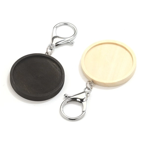 Macro-detail van ronde houten sleutelhanger trays in zwart en natuur met zilveren sluitingen