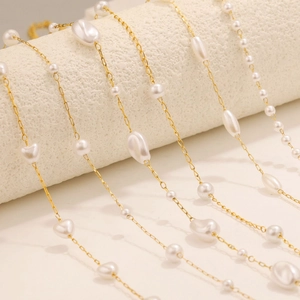 Collier doré en acier inoxydable avec perles baroques sur présentoir blanc