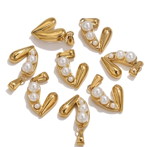 Macro detail of golden curved heart pendants featuring three elegant white pearls
