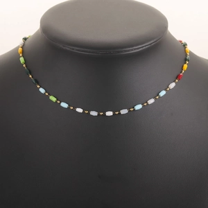 Detail of colorful cylindrical gemstones and gold spacer beads on a choker necklace