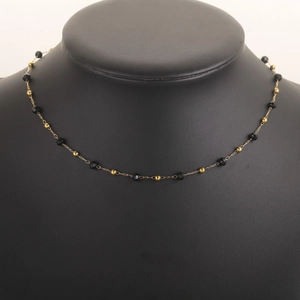 Detail of 18k gold plated chain necklace with black faceted beads on neck mannequin