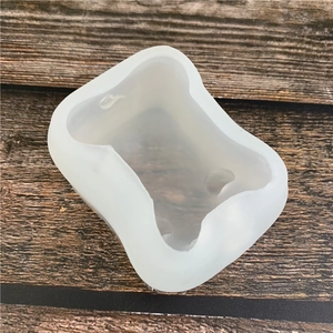 Dog bone shaped silicone mold for DIY resin crafts on a dark wood background