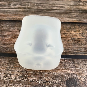 White pig-shaped silicone mousse cake and gypsum mold on a textured wooden background