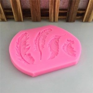 Pink silicone mold featuring four detailed feather designs for cake decor and resin craft