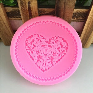 Pink round silicone mold featuring an intricate heart flower relief and beaded edge decoration