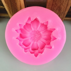 Pink circular silicone mold with detailed daisy flower design for cake decorating and DIY