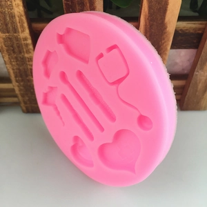 Pink circular silicone mold with DIY nurse tool shapes for fondant and cake baking