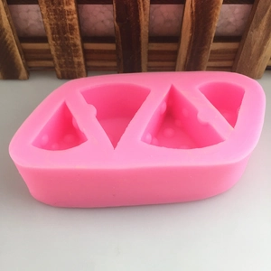 Detail of pink silicone mold with four textured cheese slice shaped cavities for DIY baking
